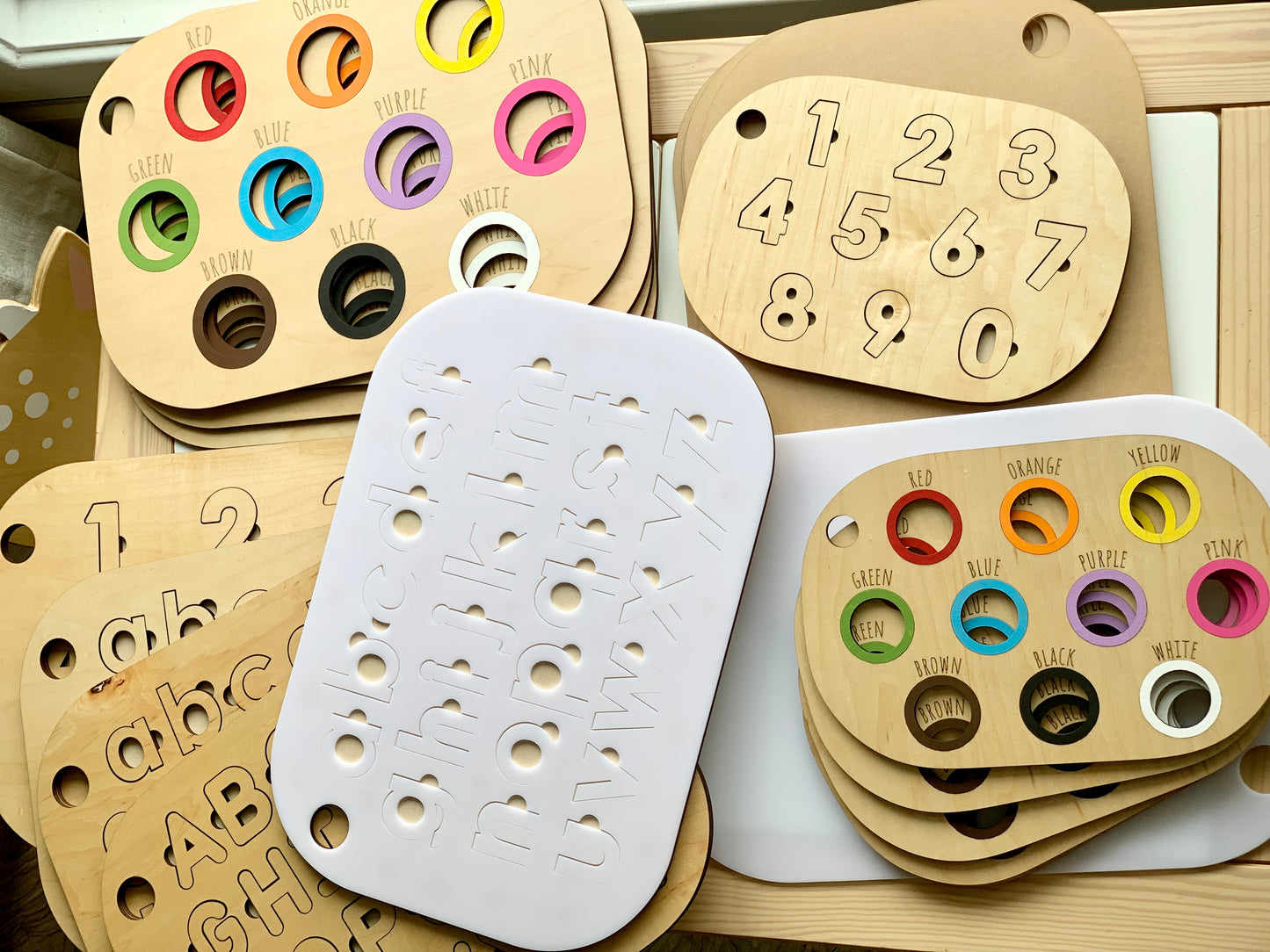 Maple plywood lowercase alphabet puzzle insert with white acrylic top pieces and number/color matching inserts on wood background