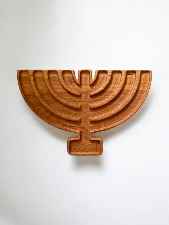 Carved wooden tray shaped like a menorah with seven branches on a plain white background