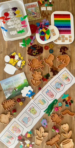 Handcrafted Bug Trays displayed with colorful wooden shapes of insects and plants, sensory fillers, educational puzzles, and spring-themed homeschool resources on a wood surface.