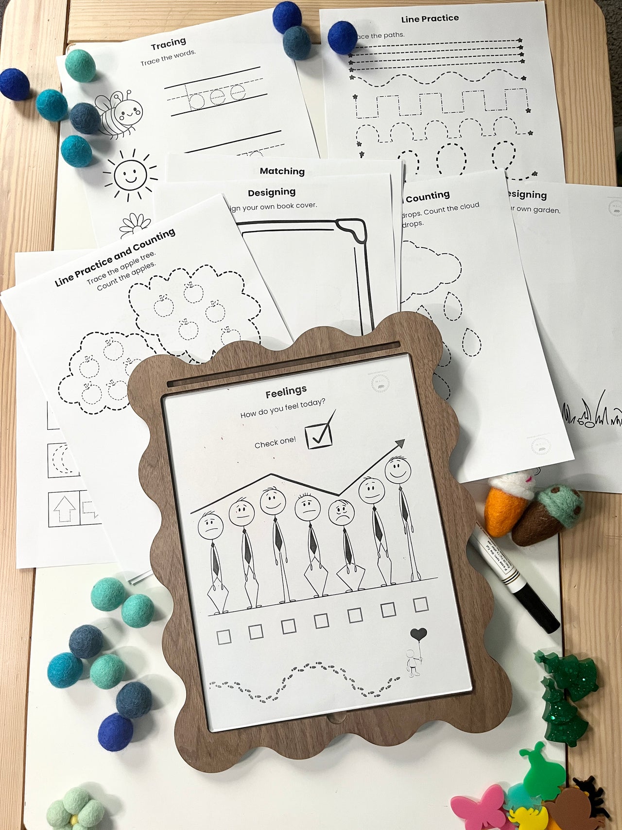 Educational worksheets on a wooden surface with a framed worksheet in the foreground.