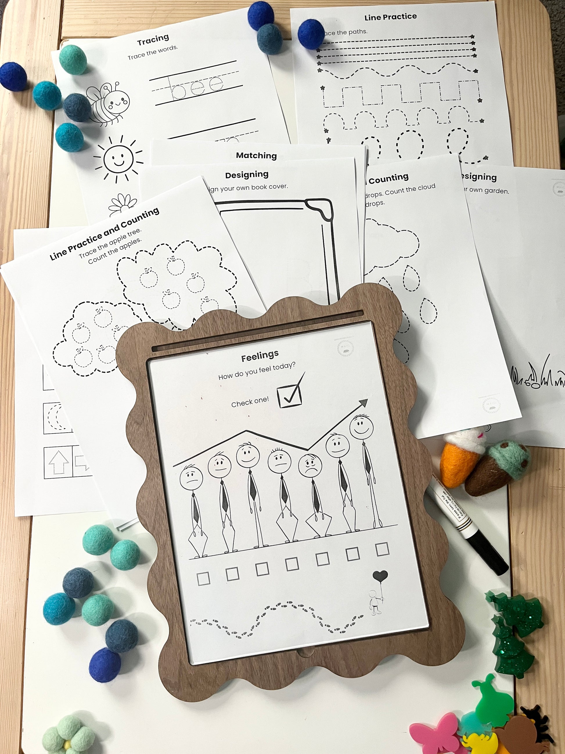 Educational worksheets on a wooden surface with a framed worksheet in the foreground.
