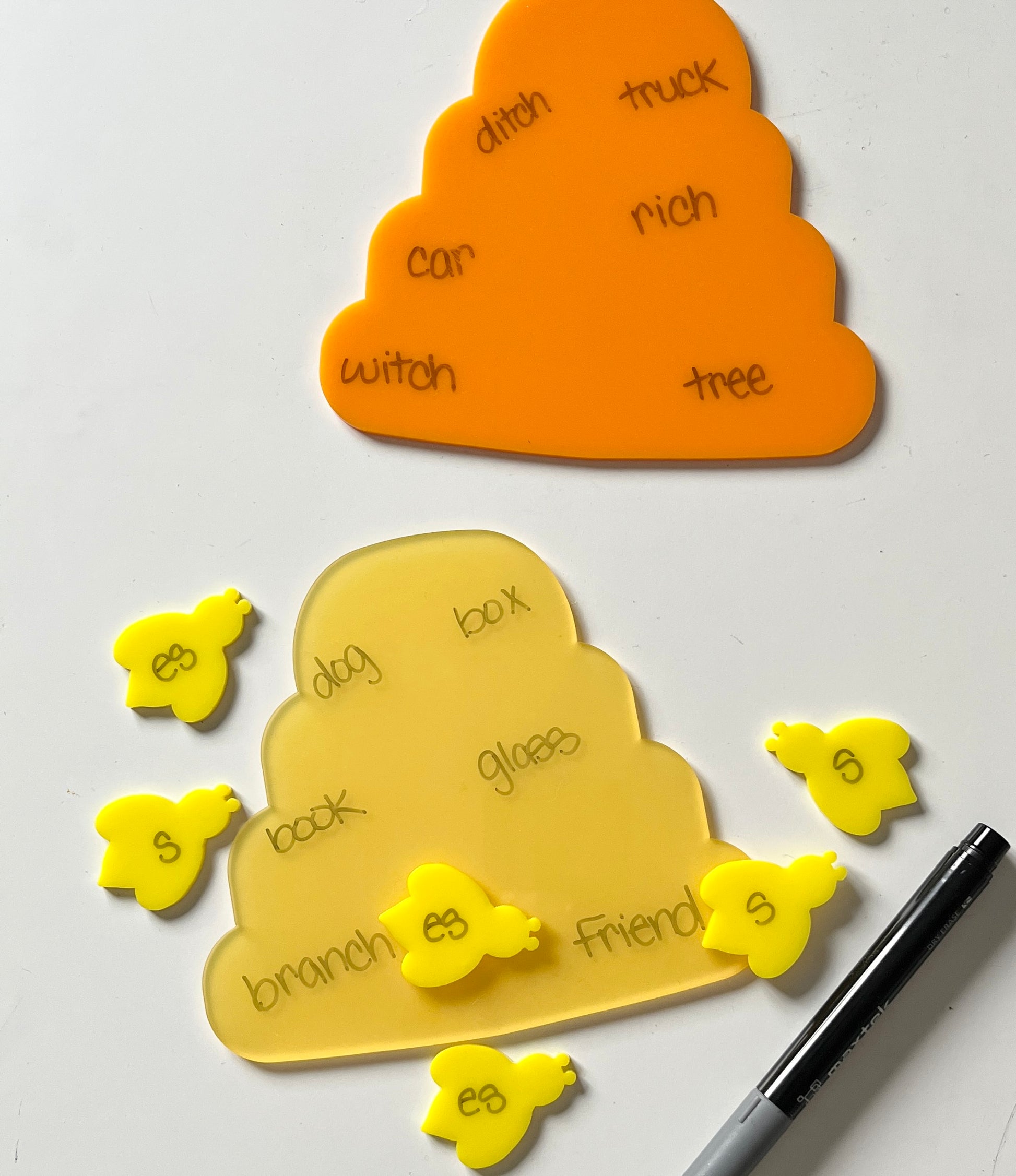 Yellow and orange bee and hive dry erase educational tools on a white background