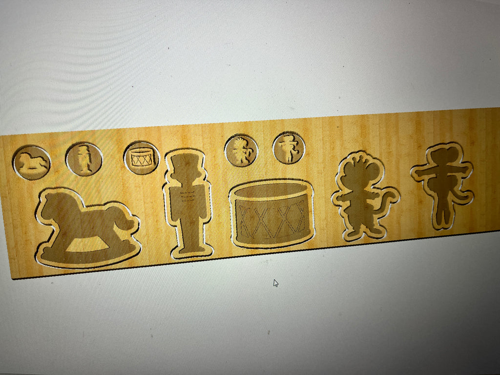 Wooden puzzle board with cutouts of a rocking horse, nutcracker, drum, clown, and gingerbread man on a light background