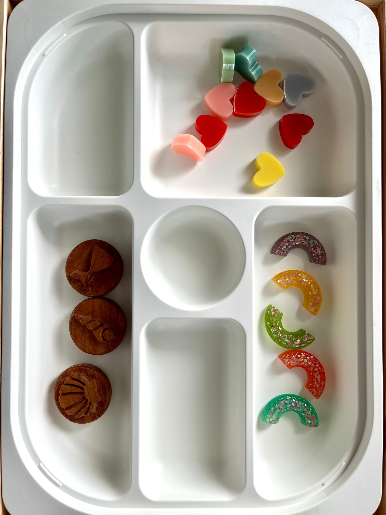 White Flisat sorting tray with wooden sea animal tokens and colorful translucent heart and rainbow shapes