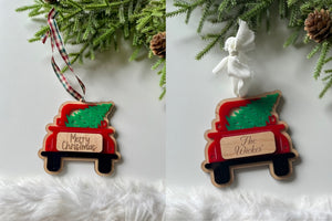 Two personalized wooden truck ornaments carrying green Christmas trees with different ribbons on white background