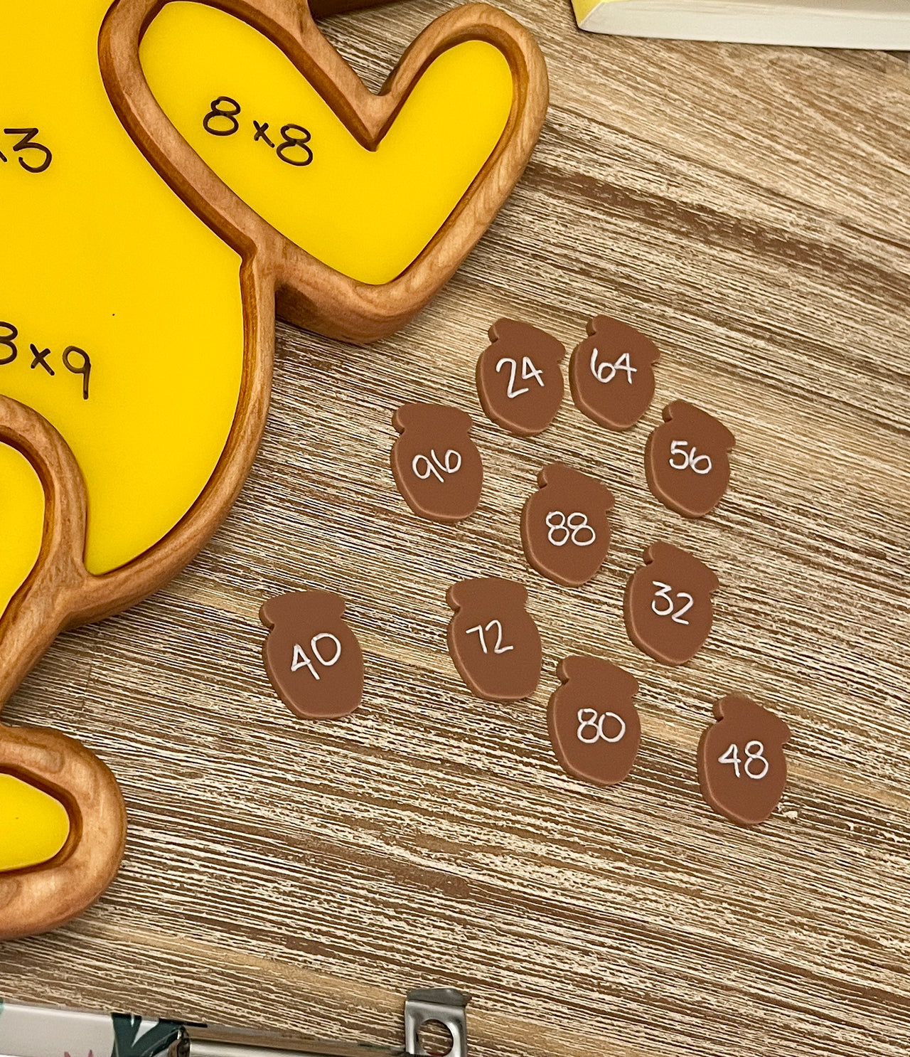 Little Dry Erasables - Set of 10 Honey Pots featuring small wooden acorn shapes with multiplication answers written on them, arranged on a wood table next to a natural wood tray, handcrafted homeschool education resources.