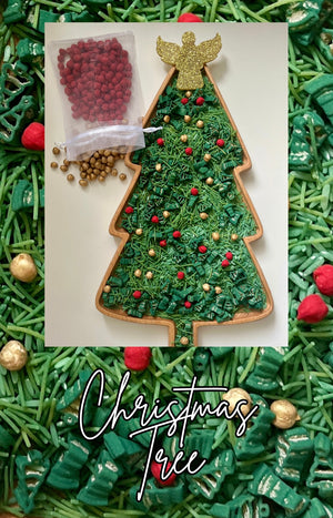 Wooden Christmas tree-shaped tray filled with green shredded paper and decorated with red and gold beads and a glittery angel topper