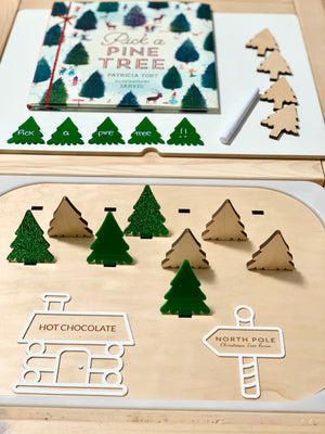 Wooden Flisat insert with maple plywood and green acrylic Christmas tree pieces plus book and chalk on white table