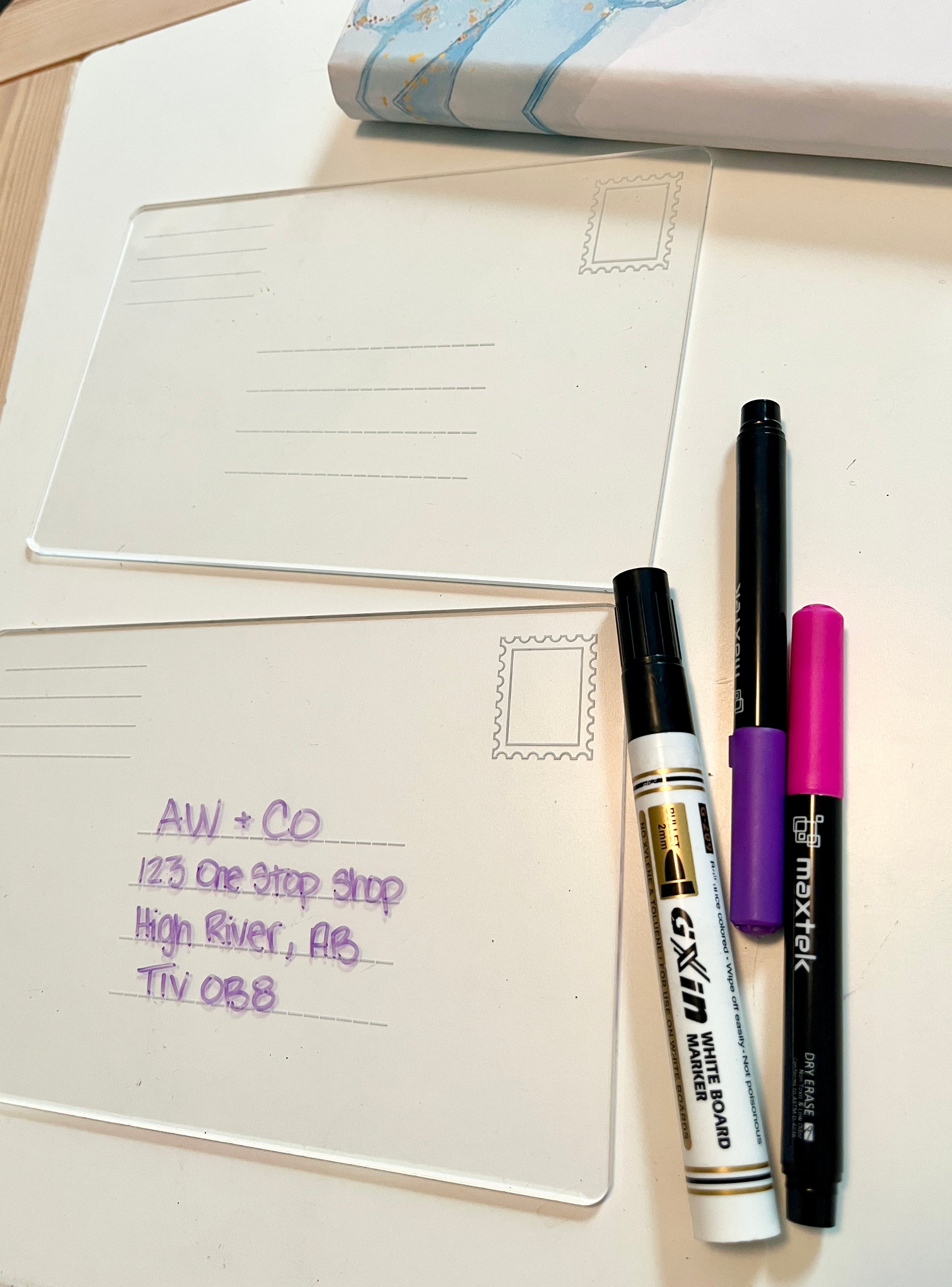 Dry erase envelope for address practice with writing and markers on a flat surface