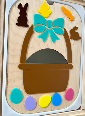 Wooden puzzle board with an Easter basket, colorful eggs, bow, chick, bunny, and carrot shapes on a light wood background