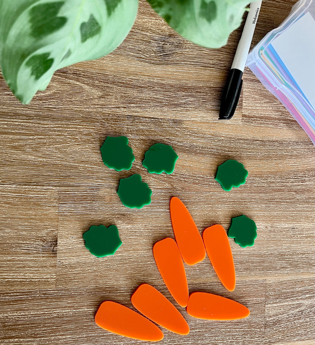 Little Dry Erasables - Small Carrots & Tops - Set of 6 / 12 Pcs Total showing bright orange carrot pieces paired with green tops arranged on a wood surface with a black marker and colorful paper, handcrafted homeschool education resources.
