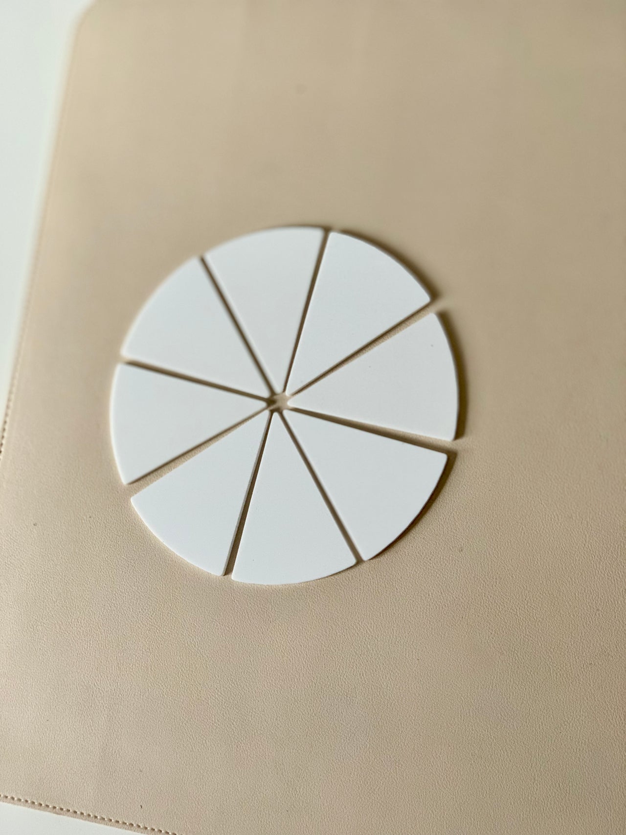 Set of eight white dry erasable pizza or pie slice shapes arranged in a circle on beige surface