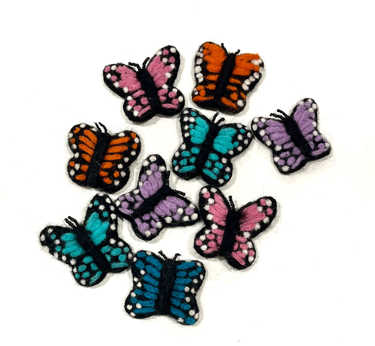Collection of small felt butterfly shapes in pink, orange, blue, and purple with black and white spotted details on white background