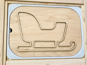 Natural wood puzzle insert featuring a sleigh outline with curved runners and a raised backrest shape