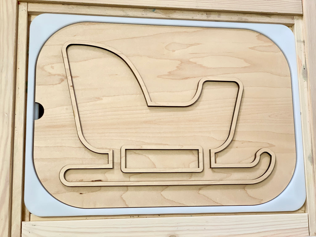 Natural wood puzzle insert featuring a sleigh outline with curved runners and a raised backrest shape