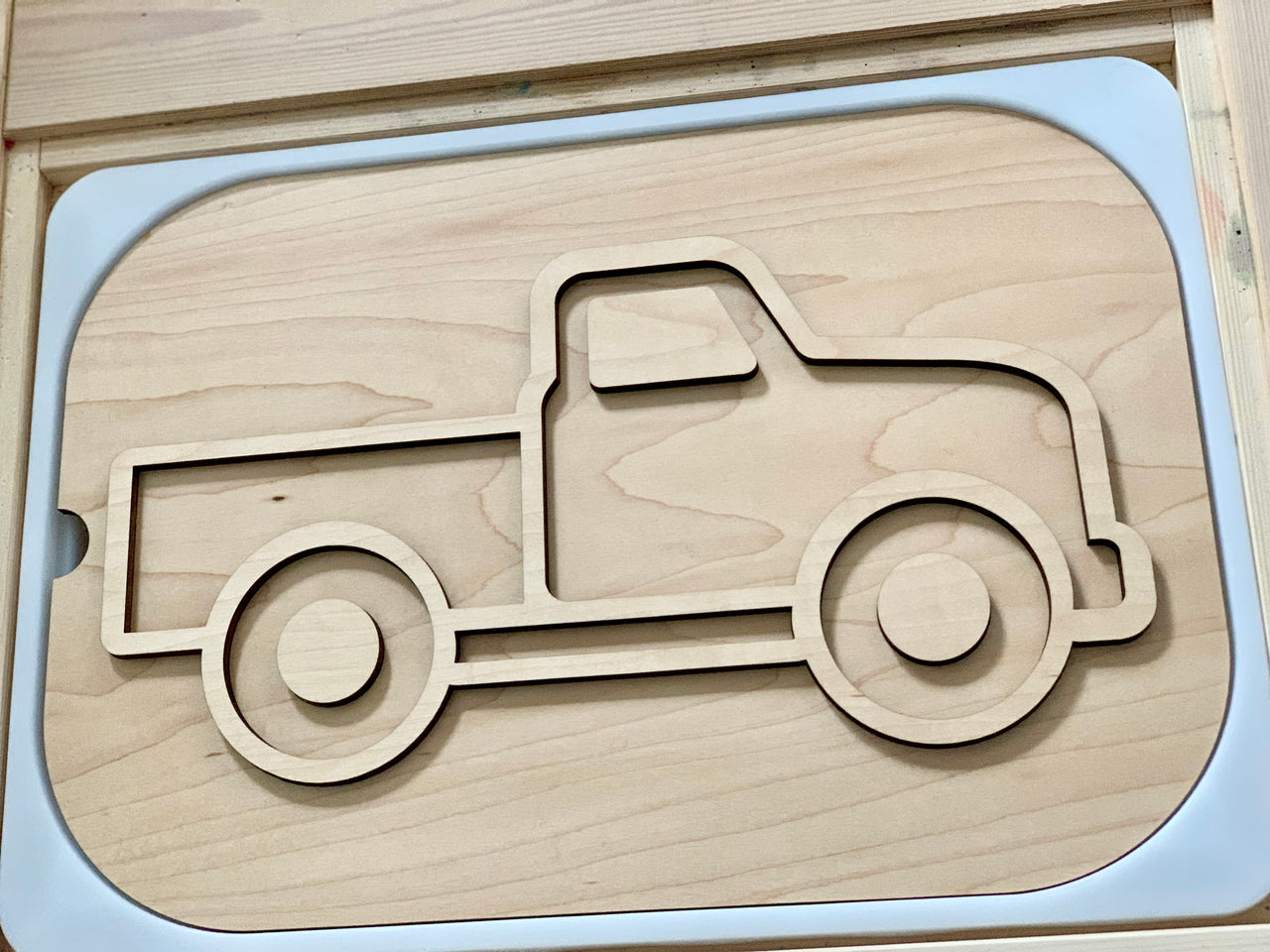 Light maple plywood truck-shaped insert with smooth rounded edges in a natural wood finish frame