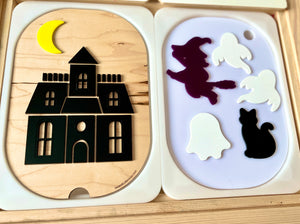 Wooden puzzle featuring a haunted house with a crescent moon and separate pieces of a witch, ghosts, and a black cat
