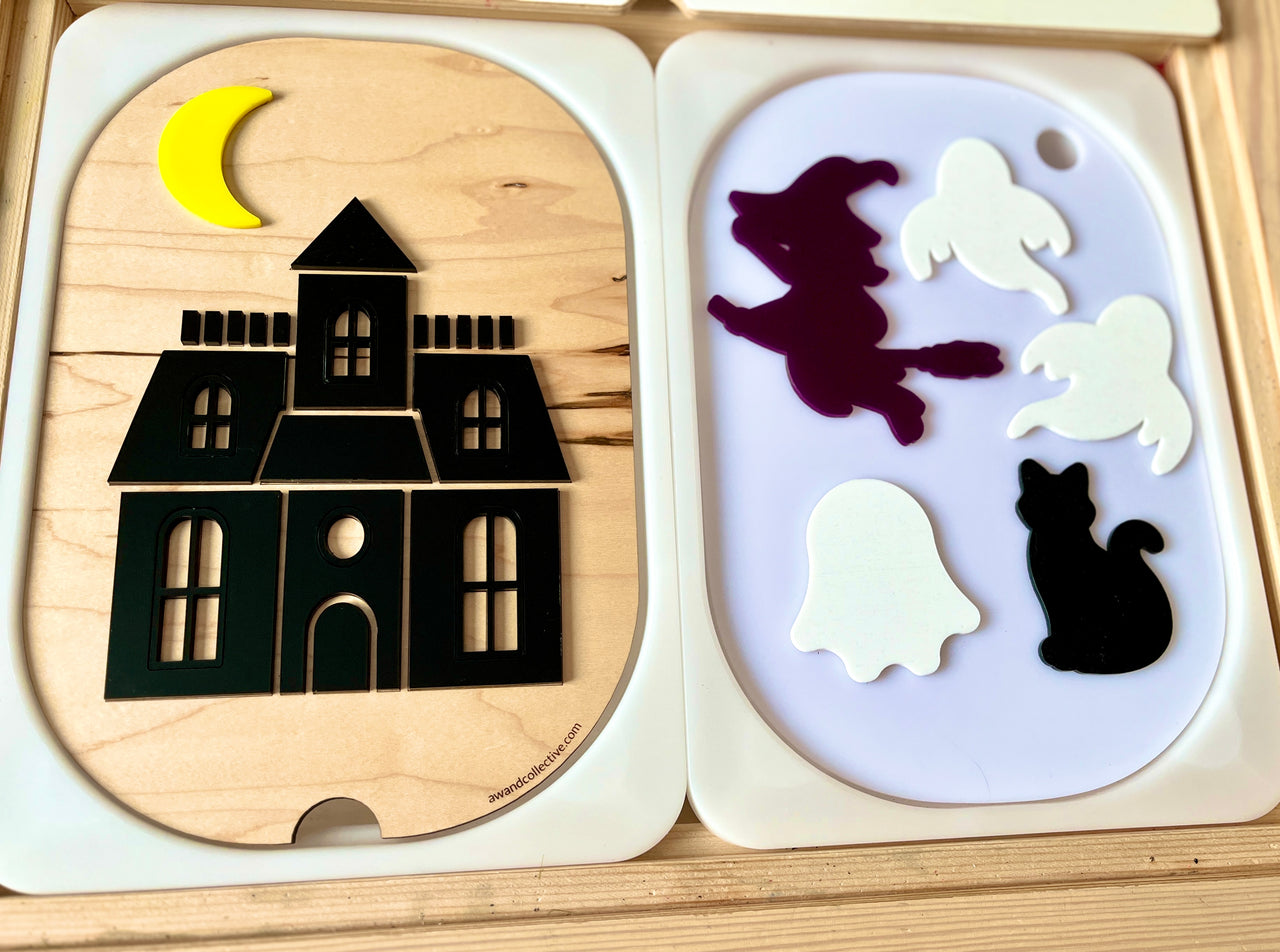 Wooden puzzle featuring a haunted house with a crescent moon and separate pieces of a witch, ghosts, and a black cat