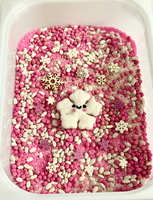 Pink snowflake sensory kit with pink filler, white beans, wooden snowflakes, and felt snowflake figure in white tray