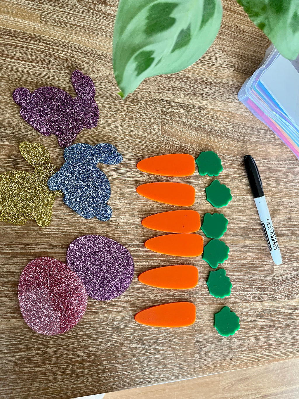 Little Dry Erasables - Small Carrots & Tops - Set of 6 / 12 Pcs Total showing bright orange carrot pieces paired with green tops alongside a black dry erase marker and colorful glittery shapes on a wood surface, handcrafted homeschool education resources.