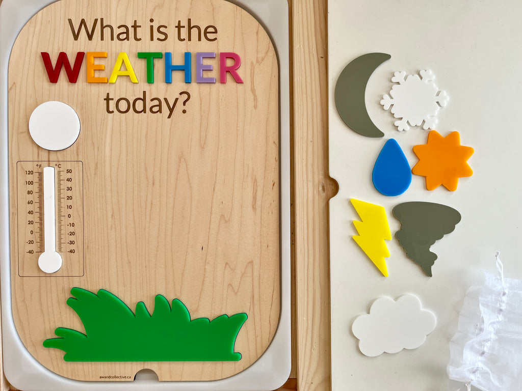 Wooden weather question board with colorful letters, magnetic thermometer, green grass, and removable weather symbol shapes nearby