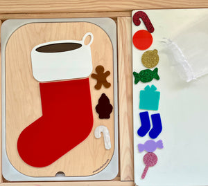 Wooden Christmas stocking puzzle pieces including a red stocking, white cuff, gingerbread man, candy cane, and tree shape on a wooden tray