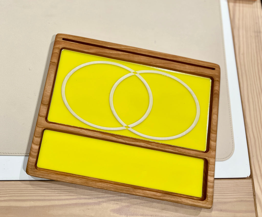 Smaller wooden multipurpose sensory tray with bright yellow dry erase inserts and overlapping circle outlines on wood surface