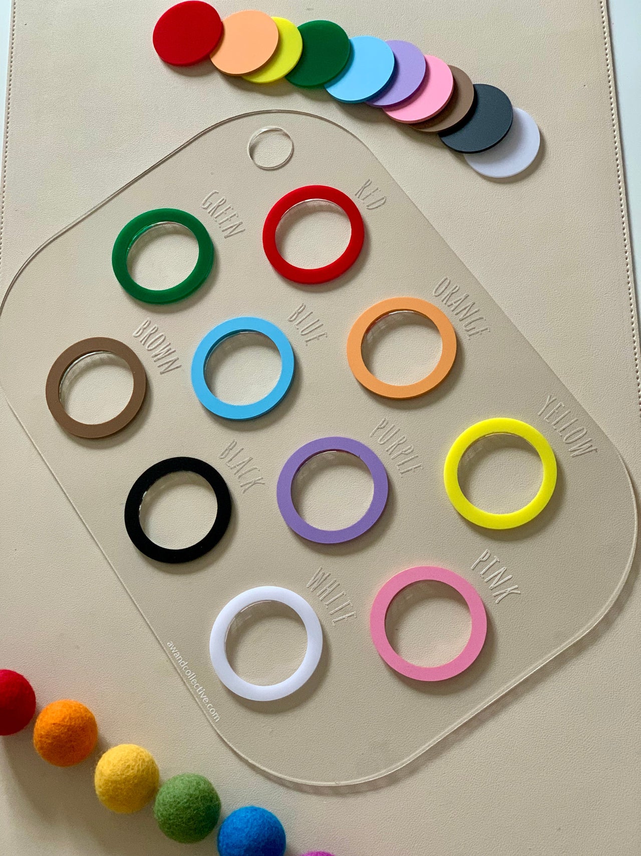Clear acrylic color chart with labeled colored rings and matching solid color discs on a beige background