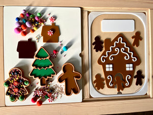 Gingerbread house, tree, and person-shaped trays with colorful pom-poms, beads, and candy decorations on wooden surface