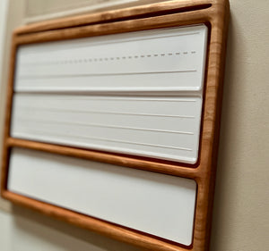 Smaller wooden multipurpose sensory tray with three white dry erase inserts featuring writing and dotted guide lines on wall background
