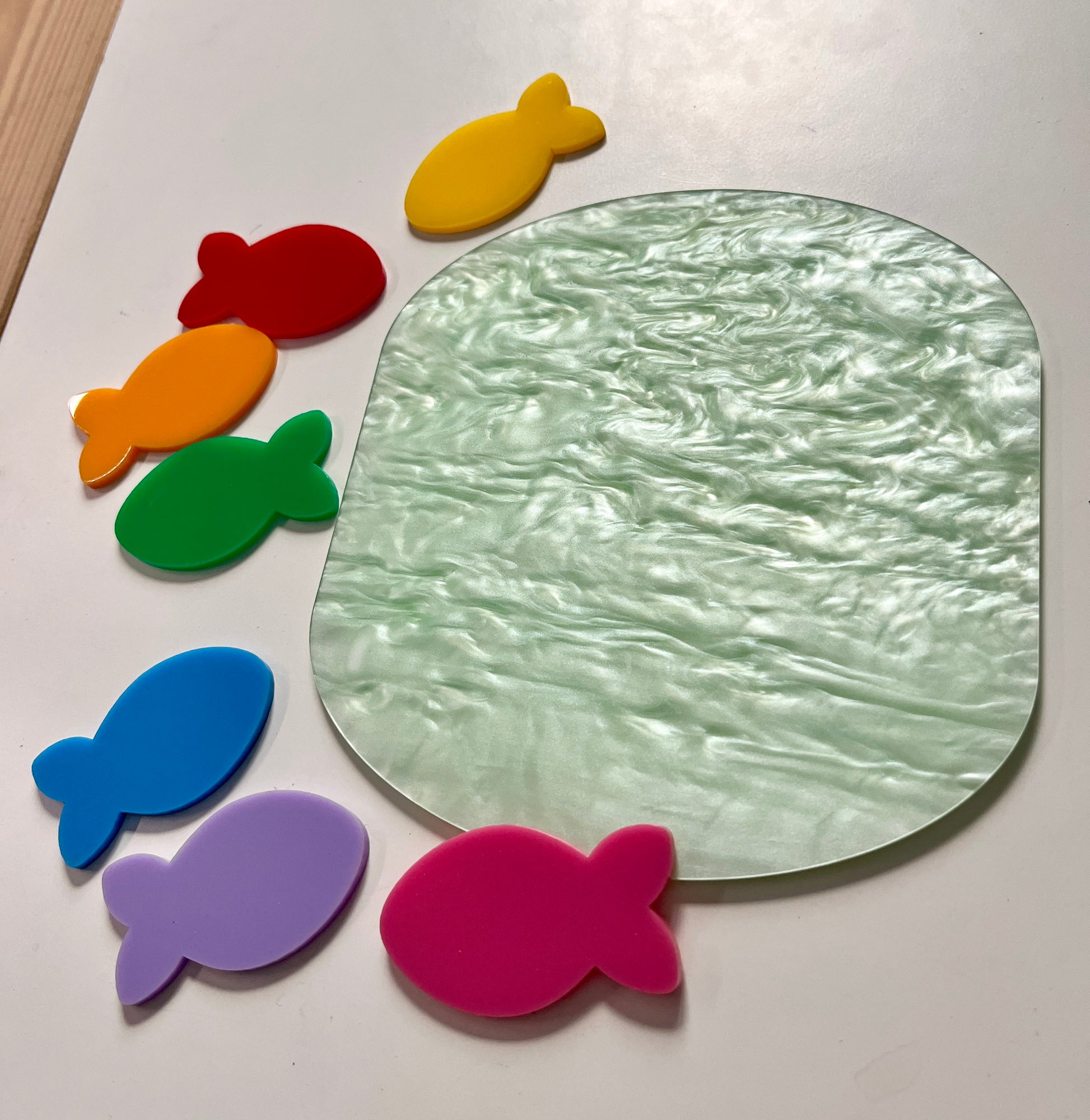 Colorful dry erase fish around a marble dry erase pond on a white background