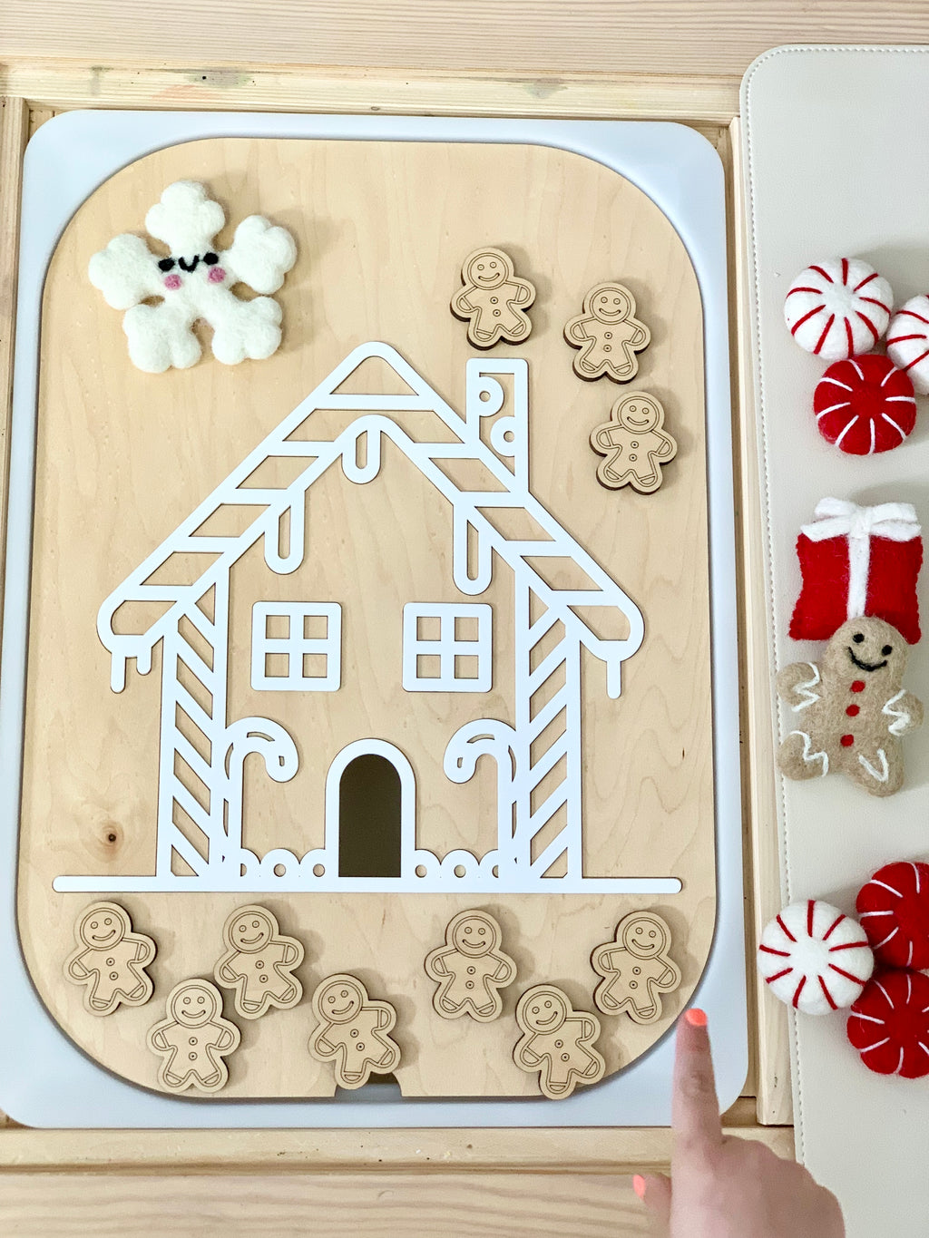 Maple wood gingerbread house Flisat insert with white acrylic roof and ten small wooden gingerbread people on table