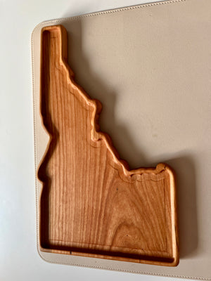 Smooth wooden tray crafted in the shape of Idaho with visible wood grain on a light surface