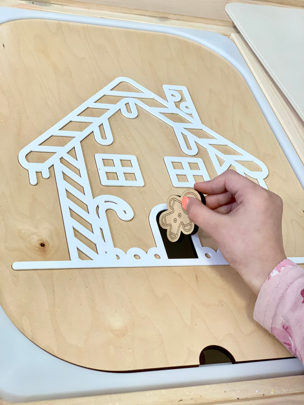 Wooden gingerbread house Flisat insert with acrylic outline and child placing small wooden gingerbread person in door