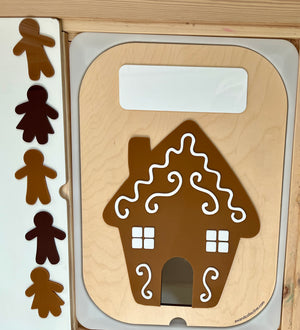 Wooden gingerbread house puzzle board with decorative white icing details and five brown gingerbread figure pieces nearby