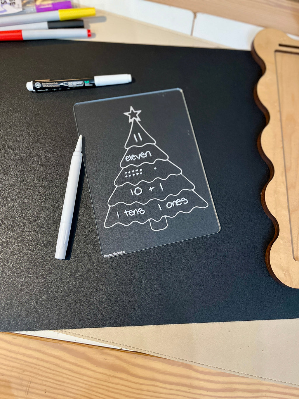 Clear plastic learning board shaped like a Christmas tree showing number eleven with tens, ones, addition, and Braille labels on black mat
