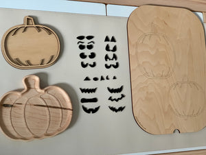 Wooden jack o lantern pumpkin trays with laser cut pumpkin face shapes and pumpkin outline trays on white surface