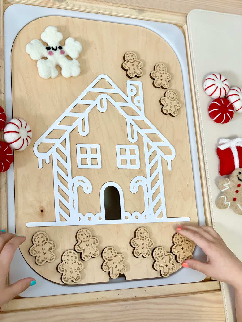 Maple plywood gingerbread house Flisat insert with 10 wooden gingerbread people and felt holiday decorations on table