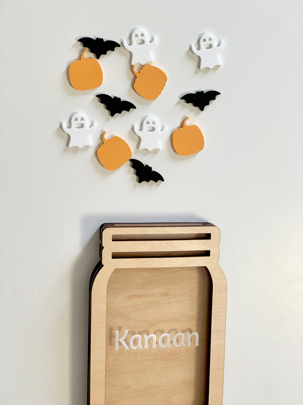 Personalized wooden reward jar with Halloween-themed pumpkin, ghost, and bat tokens on white background