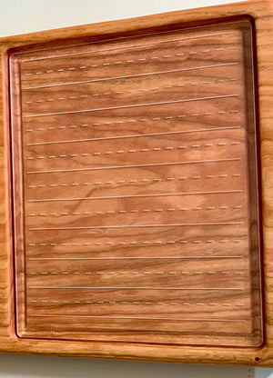 Wooden-framed clear board with horizontal dashed and solid lines for handwriting or calligraphy practice on wood surface