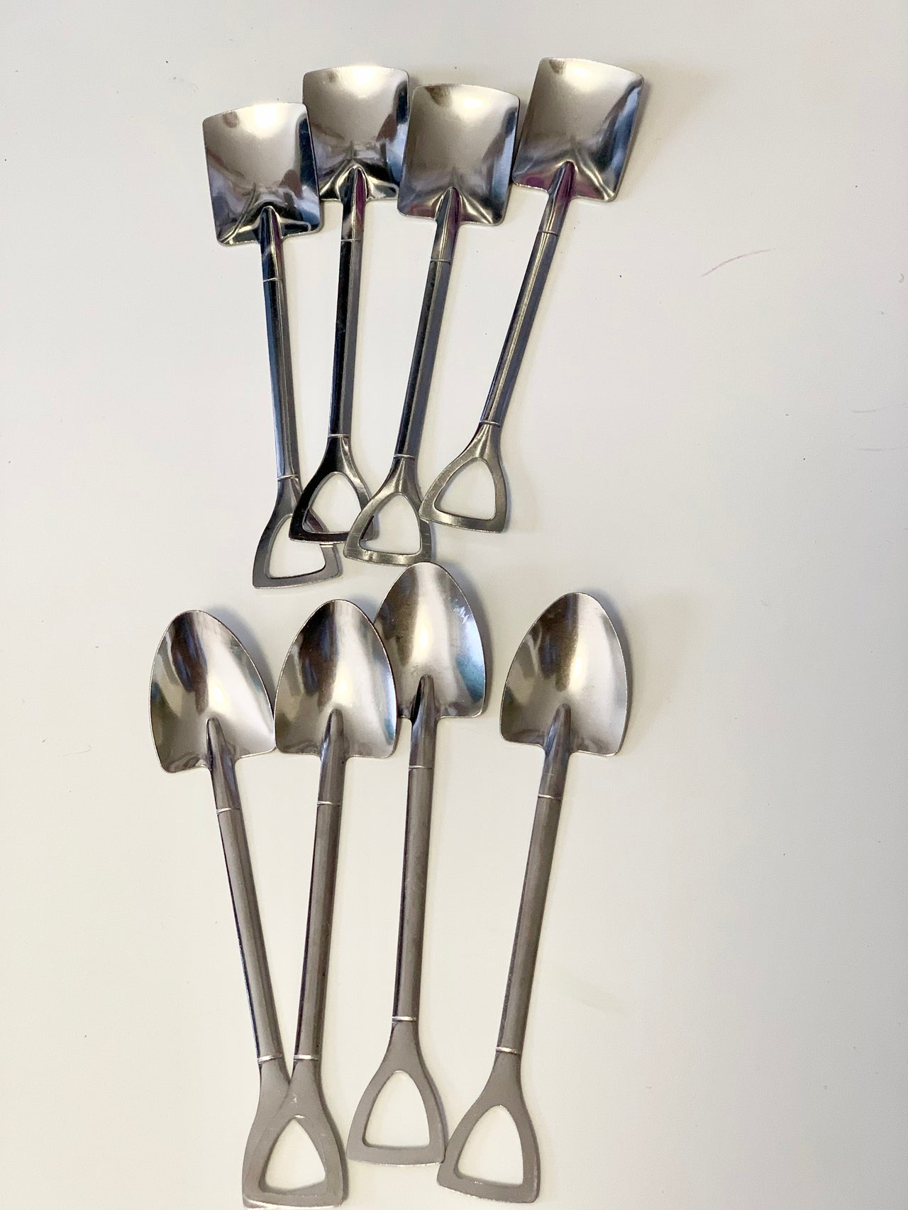 Set of small metal shovels in two styles with rounded and square blades on white background