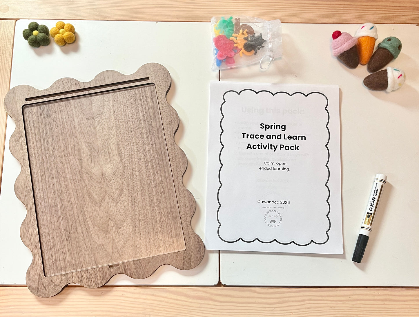 Spring Trace and Learn Activity Pack with wooden board, markers, and educational materials on a wooden surface.