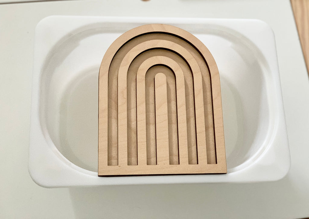 Laser cut wooden rainbow tray insert fitting inside small white Trofast bin on light wood surface