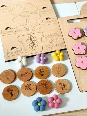 Wooden flower parts puzzle board with engraved labels and floral memory game tokens with felt flower pieces on white surface