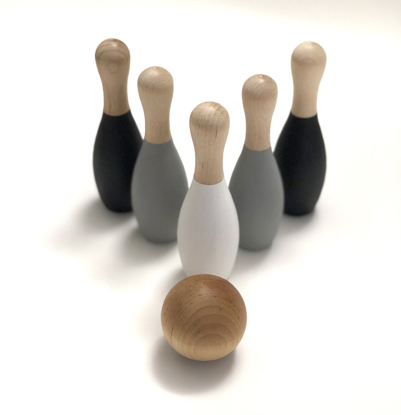 Monochrome wooden bowling set with five skittles in black, gray, and white, and a natural wood ball for toddlers.