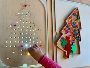 Wooden Christmas tree peg insert with light-up holes and colorful acrylic present pegs on natural wood surface