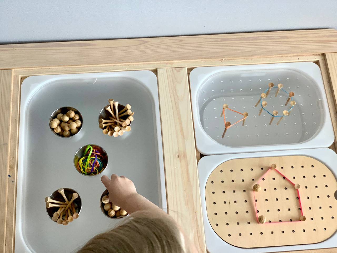 Light maple Tinker Pot Flisat tabletop insert with acrylic cups, metal pegs, and rubber bands for creative play activities