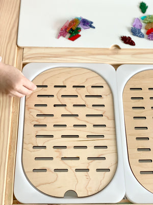 Flisat table top insert with wooden slots sorter showing small bin size and child's hand placing item into slot