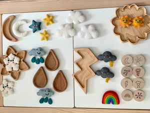 Wooden weather memory game pieces including felt clouds, stars, raindrops, lightning bolt, sun, moon, rainbow, and wooden discs with weather icons