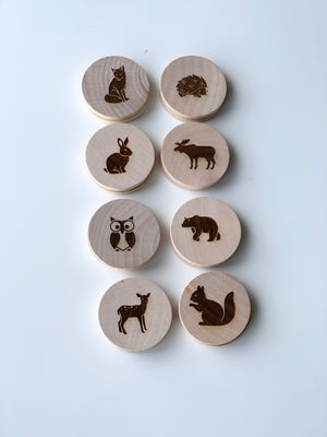Wooden 2-inch discs with engraved woodland animal illustrations arranged in two neat vertical columns on white background